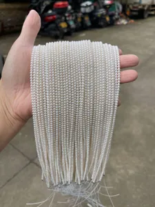 Detailed close-up view of strands of natural white freshwater round pearls held in hand
