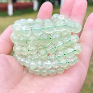 Fili di perline rotonde di prehnite verde naturale in mano