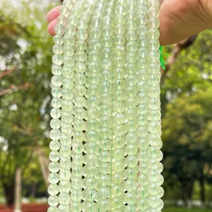 Primo piano di perle rotonde in prehnite verde traslucido naturale per fai da te