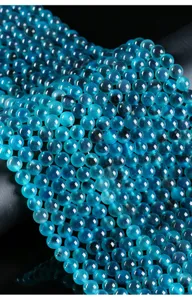 Detailed macro view of translucent 6mm blue candy heart agate round beads for DIY crafts