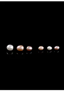 Macro view of assorted natural freshwater rice-shaped pearls with high luster on black