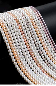 Close-up of various natural freshwater pearl strands in white, pink, and lavender colors