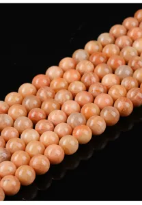 Macro detail of polished natural red amazonite round beads for DIY jewelry making.