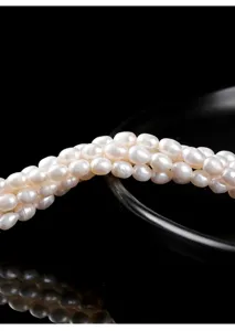 Gedetailleerde close-up van natuurlijke witte zoetwaterrijstparels voor DIY-sieraden.