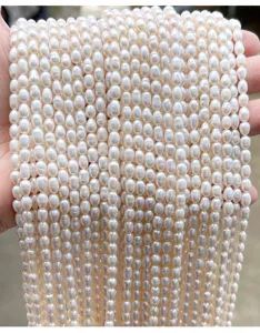 Close-up van meerdere strengen natuurlijke witte zoetwaterrijstparels voor DIY-sieraden.
