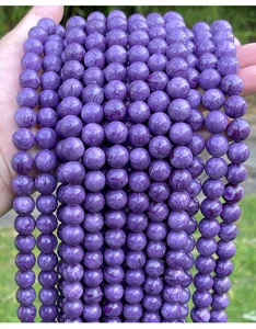 Detailed macro view of imitation charoite loose beads showing vibrant purple silk texture
