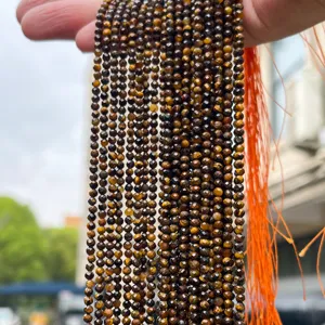 Detailed close-up of faceted natural yellow tiger eye round beads for DIY jewelry making