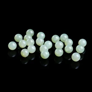 Natural translucent Qinghai Hetian jade round beads for DIY jewelry making on black surface