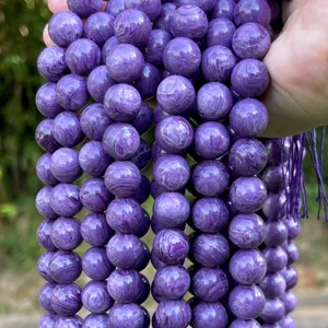 Strands of round purple imitation Charoite beads with natural-looking white swirl patterns.