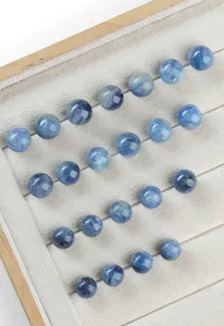Detailopname van natuurlijke blauwe kyaniet ronde kralen op een grijs fluwelen display
