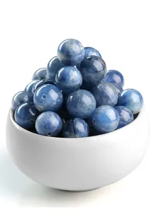 Detail van natuurlijke blauwe kyaniet kralen in een witte kom voor het maken van sieraden