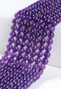 Macro view of polished natural purple amethyst round beads for DIY jewelry making crafts