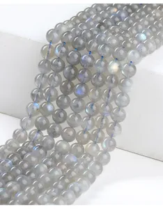 Makroaufnahme von 4mm Naturgrauen Mondsteinperlen mit brillantem blauem Glanzeffekt.