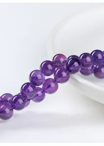 Macro detail shot of natural amethyst round beads showing rich translucent purple texture.