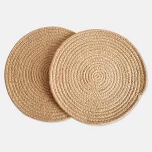 Detail shot of two round woven jute placemats with a minimalist natural fiber texture.