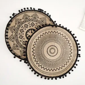 Detailansicht runder Jute-Tischsets mit schwarzen Quasten und geometrischen Mustern.