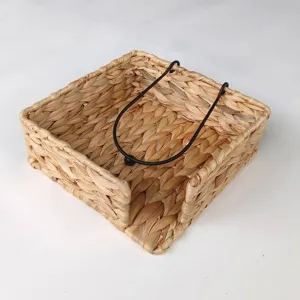 Detalle de servilletero tejido a mano de jacinto de agua con barra de metal pesada.
