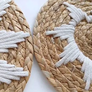 Close-up detail of bohemian round woven wall decor with white cotton rope accents.