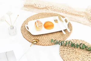 Detailed scene of a handwoven straw placemat with ceramic plate and golden cutlery setup