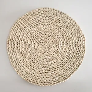 Natural corn husk woven placemat detail showing intricate braided spiral texture clearly.
