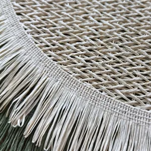 Close-up of round paper rope placemat with woven fringe, textured hollow tabletop decor.