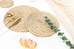 Handwoven straw placemat detail, natural cattail dining table mat with chic tableware decor.