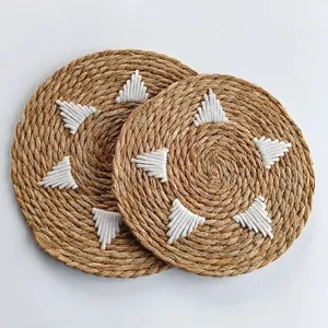 Macro view of two circular woven seagrass placemats with decorative white rope accents
