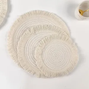 Detailed shot of woven cotton fringe placemats, Nordic style round table mat close-up.