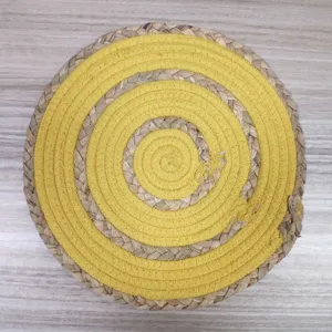 Close-up detail of the hand-woven yellow cotton rope and natural straw circular placemat texture.