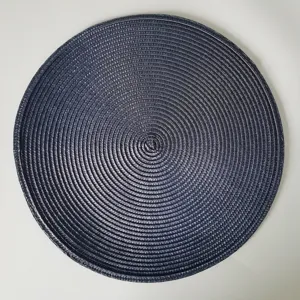 Primo piano di una tovaglietta rotonda in tessuto PP scuro con dettagli di trama circolare.