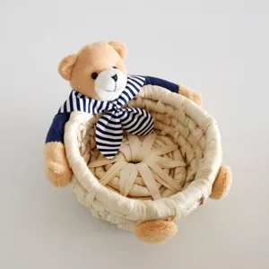 Detailed close-up of a woven straw storage basket featuring a cute plush teddy bear with sailor collar.