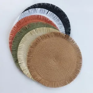 Vue rapprochée de sets de table tissés ronds empilés avec des franges délicates en couleurs.