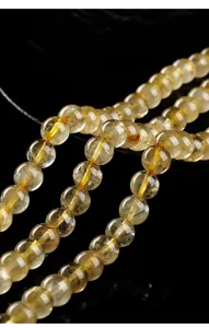 Macro detail of natural golden rutilated quartz round beads for DIY jewelry making