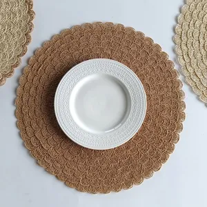 Close-up detail of round woven placemat showing intricate straw texture and wavy edge design.