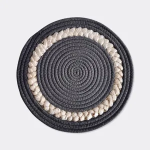 Close-up of Nordic style round braided cotton rope heat insulation table mat texture.