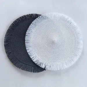 Set de table rond en paille de papier tissée avec bord à franges, style minimaliste.