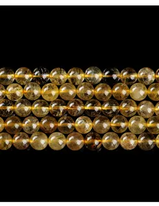 Macro detail view of natural golden rutilated quartz round beads for DIY jewelry making