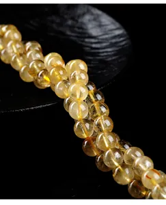 Close-up detail of natural golden rutilated quartz round beads for DIY jewelry