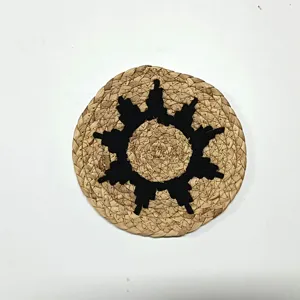 Détail de tenture murale ronde en paille artisanale, motif de soleil noir ethnique, déco.