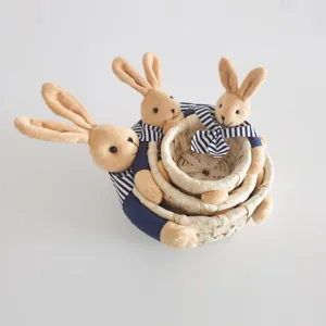 Detailed view of straw woven storage baskets set of three featuring cute rabbit plush toys.