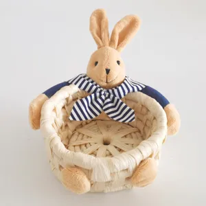 Straw woven storage basket detail with cute plush rabbit doll and blue striped bow for home.