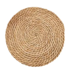 Natural straw woven placemat circular heat insulation pad for dining table and kitchen use.