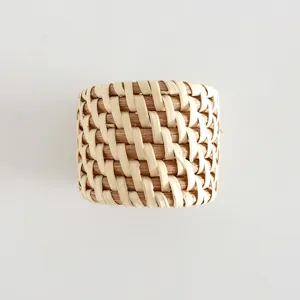 Handwoven rattan napkin ring for rustic dining table decor, natural straw napkin holder.
