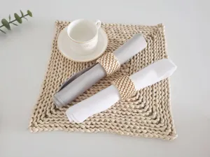 Modern minimalist woven napkin rings set with cloth napkins and placemat for table decor.