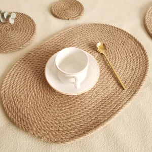 Nahaufnahme von natürlichen geflochtenen Jute-Tischsets mit Keramiktasse und Löffel.