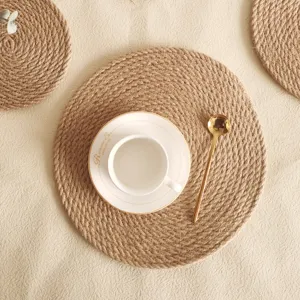 Detaillierte Draufsicht auf rundes geflochtenes Jute-Tischset mit Kaffeetasse