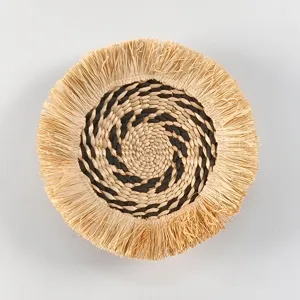 Bohemian woven wall hanging with raffia fringe, round straw decor for home interior detail.