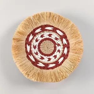 Close-up of the woven wall hanging featuring detailed bohemian fringe and concentric patterns.