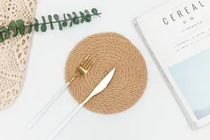 Detaillierte Nahaufnahme eines handgewebten Jute-Untersetzers mit minimalistischem Goldbesteck