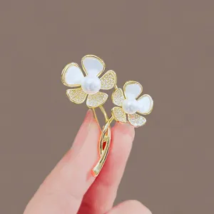 Detailed macro view of elegant gold flower brooch with white pearls and rhinestones
